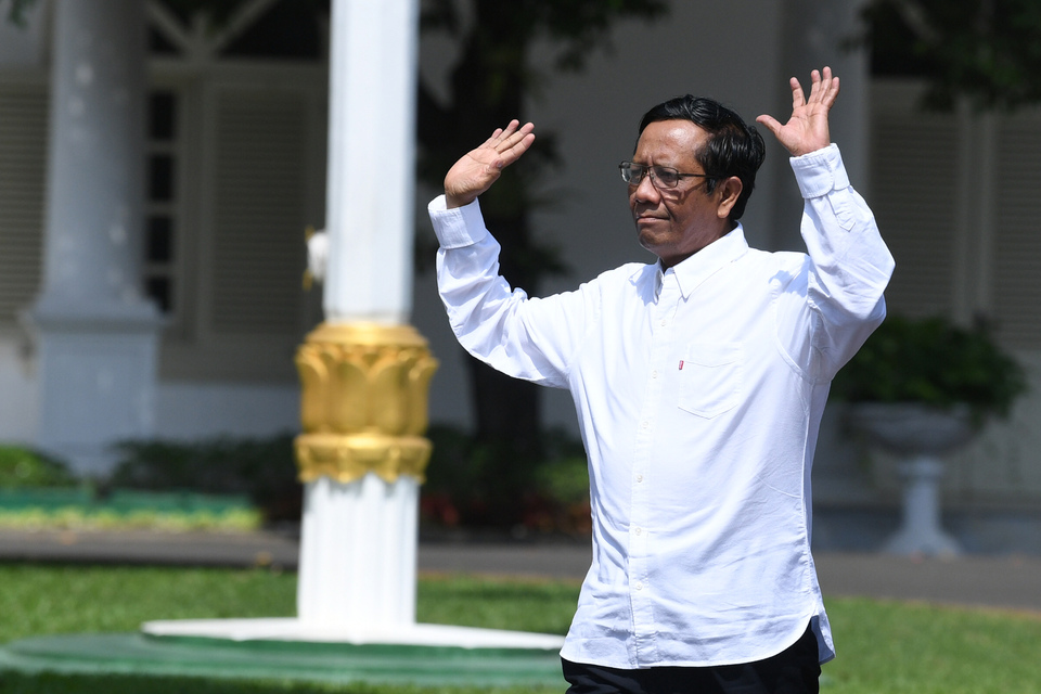 FILE-  Mohammad Mahfud MD greets reporters at the State Palace in Jakarta during the selection of cabinet members on Oct. 21, 2019. (Antara Photo)