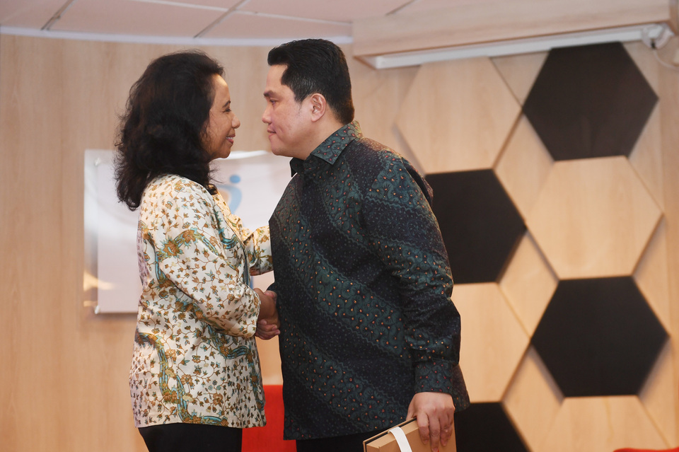 Newly appointed State-Owned Enterprises Minister Erick Thohir, right, shakes hands with his predecessor Rini Soemarno during their handover ceremony in Jakarta on Wednesday. (Antara Photo/Akbar Nugroho Gumay)