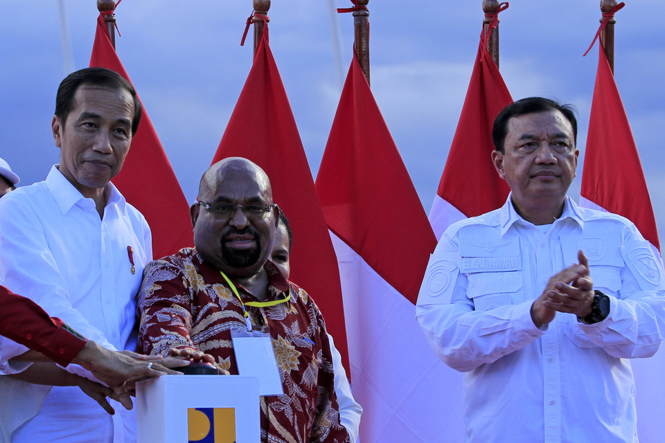President Joko Widodo, left, and Papua Governor Lukas Enembe, center, press a bottom to open the Youtefa Bridge in Jayapura, Papua, on Monday. (Antara Photo/Gusti Tanati)