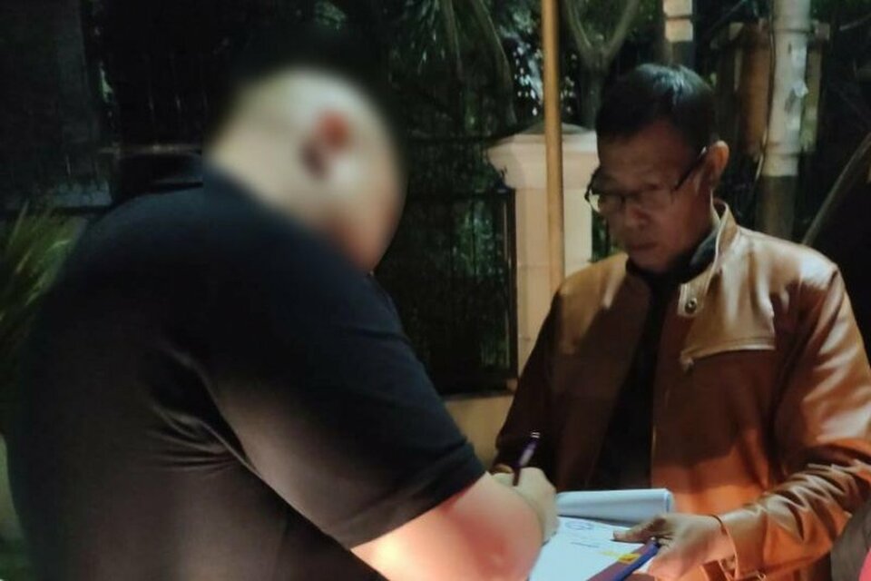 A businessman identified by his initials D.S.T., left, signs his arrest warrant for tax evasion on Monday, in this handout photo from the East Java Tax Office. (Antara)