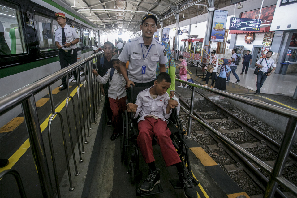 A railway official assists a student of Bantul 1 Special Needs Schools to board a train at Tugu Station in Yogyakarta on Tuesday.  The students participated in a trial of facilities for disabled people at the station. (Antara Photo/Hendra Nurdiyansyah)