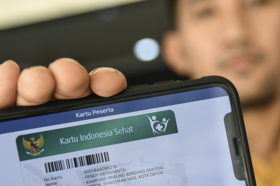 A BPJS Kesehatan officer displays his digital health insurance card in Jakarta on Sep 13, 2019. 
(Antara Photo/Muhammad Adimaja)