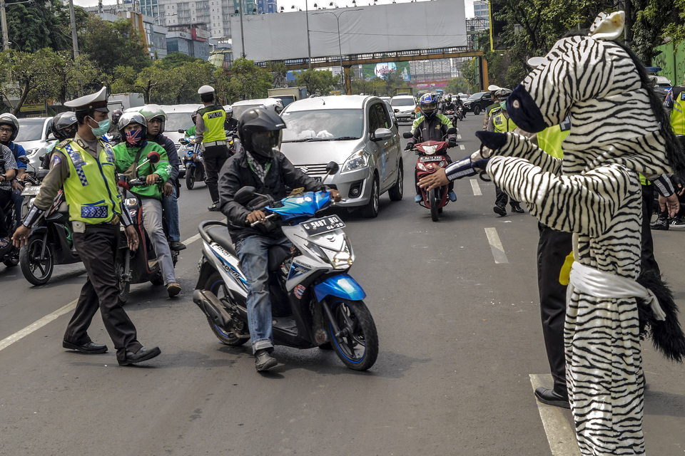 Police officers conduct a traffic stop as part of Operation Zebra Jaya 2019 in Bekasi, West Java, on Monday. The operation is aimed at raising public awareness of traffic and pedestrian safety. Police are also intensifying law enforcement efforts to clamp down on traffic offenders and unlicensed drivers. (Antara Photo/Fakhri Hermansyah)
