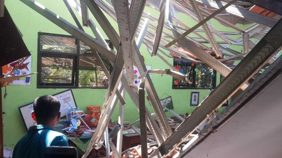 A 19-year-old teacher and an 8-year-old student were killed, and at least 12 others were injured, two of them seriously, when the roof of Gentong State Elementary School in Pasuruan, East Java, collapsed on Tuesday morning. (Photo courtesy of BNPB)
