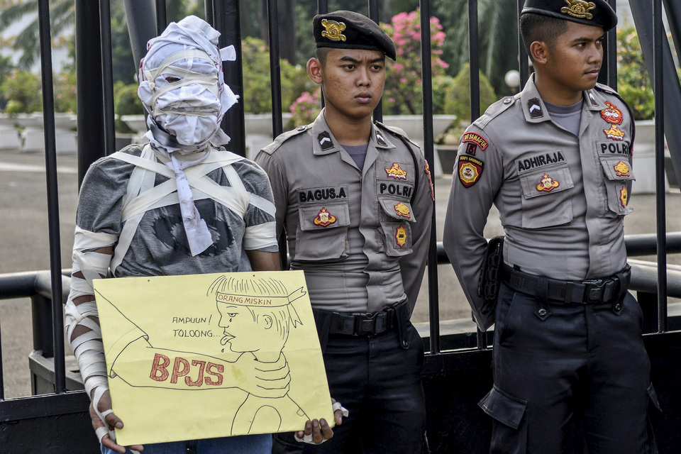 A demonstrator protesting against a premium hike in the national health insurance scheme (BPJS Kesehatan) in front of the House of Representatives compound in Central Jakarta on Monday. (Antara Photo/Aditya Pradana Putra)
