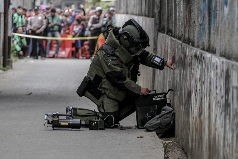 A member of the National Police bomb disposal unit gingerly approaches a bag thought to contain a bomb in Depok yesterday. (Antara Photo/Asprilla Dwi Adha)