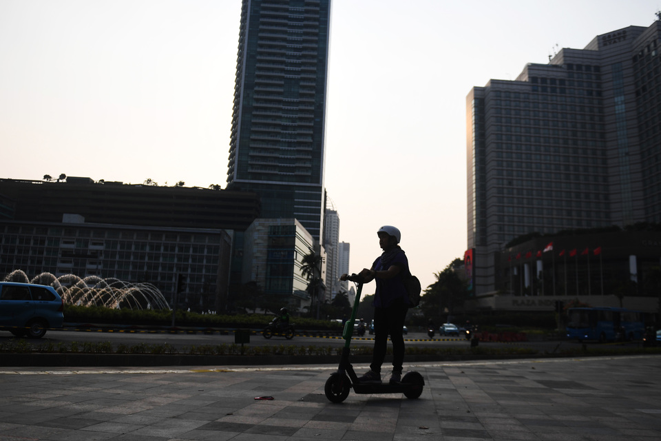 This 2019 file photo shows a rider with their electric scooter at BunderanHotel Indonesia in Central Jakarta. (Antara Photo/Akbar Nugroho Gumay)