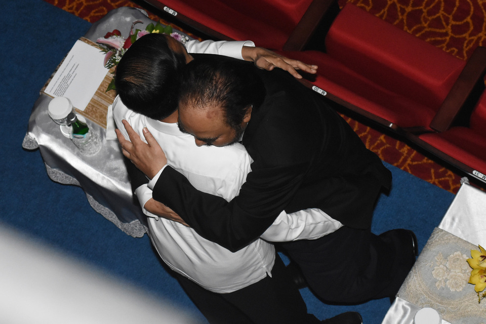 President Joko Widodo, left, is being embraced by Nasdem Party chairman Surya Paloh during the party's congress in Jakarta on Nov. 11. (Antara Photo/Indrianto Eko Suwarso)