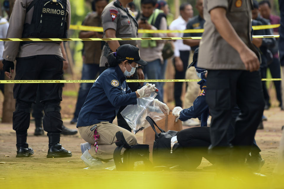 The National Police's forensic team collects evidence from the blast site at the National Monument in Central Jakarta on Tuesday morning. (Antara Photo/Nova Wahyudi)
