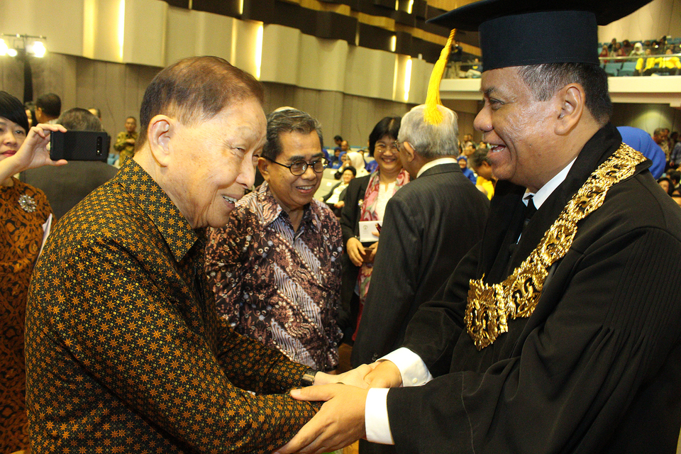 Ari Kuncoro, right, receives congratulations from former chairman of University of Indonesia's Board of Trustees Mochtar Riady after being inaugurated as chancellor in Depok, West Java, on Wednesday. (B1 Photo/Emral Firdiansyah)
