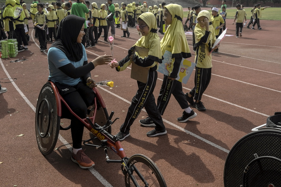 Tamirul Islam high school students offer flowers para-athletes training for the Asean Para Games 2020 in Solo, Central Java, on Wednesday. (Antara Photo/Maulana Surya)