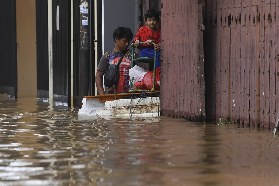 A boy being evacuated from a house in Sawah Besar, Central Jakarta, on Thursday. (Antara Photo/Wahyu Putro A.)