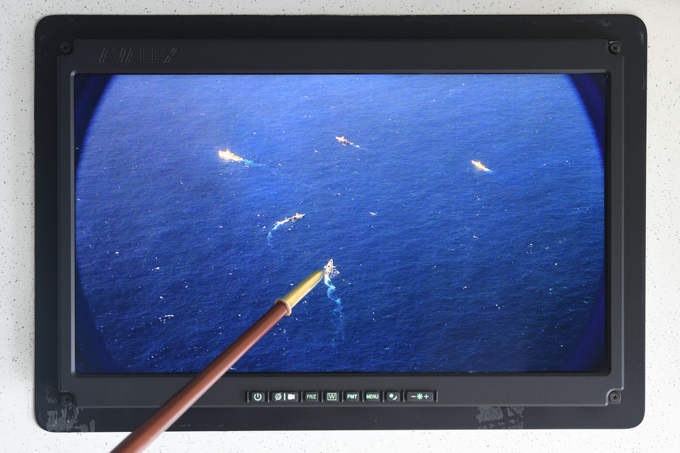 An Indonesian military officer shows footage of an encounter between an Indonesian warship and a Chinese Coast Guard ship on the Natuna Sea during a briefing aboard the Air Force’s Boeing 737 surveillance plane on April 1, 2020. (Antara Photo/M Risyal Hidayat)