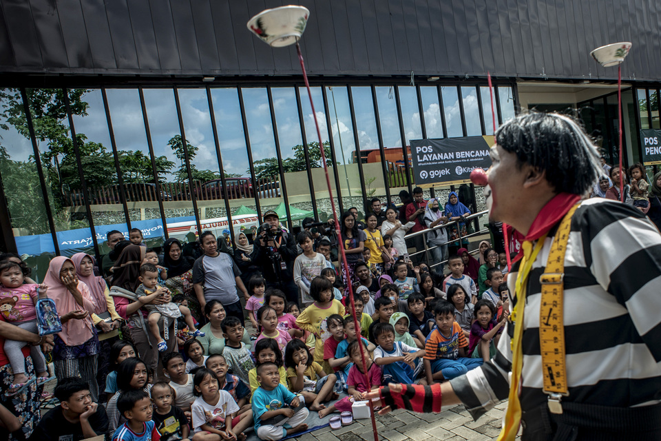 A clown entertains children at a flood evacuation shelter in Pancoran, South Jakarta, on Tuesday. (Antara Photo/Aprillio Akbar)