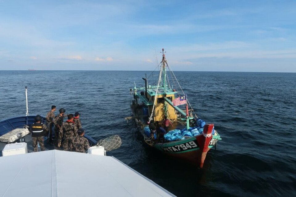 An Indonesian patrol boat operated by the Maritime Affairs and Fisheries Ministry apprehends a Malaysian fishing boat in the Indonesian waters in November 2019. (Photo courtesy of Maritime Affairs and Fisheries Ministry)