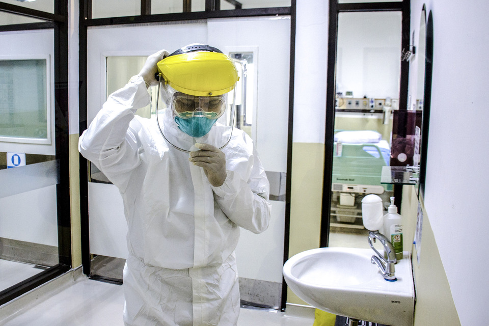A medical officer in protective gear prepares an isolation room for Covid-19 patients at Dokter Hasan Sadikin Hospital in Bandung, West Java, on Friday. (Antara Photo/Novrian Arbi)