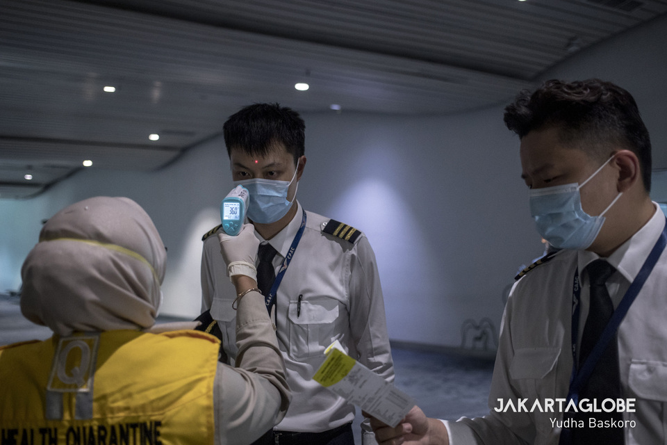 Two pilots who just arrive from Hongkong are inspected by a health inspector at Soekarno-Hatta International Airport on Jan. 28. (JG Photo/Yudha Baskoro)