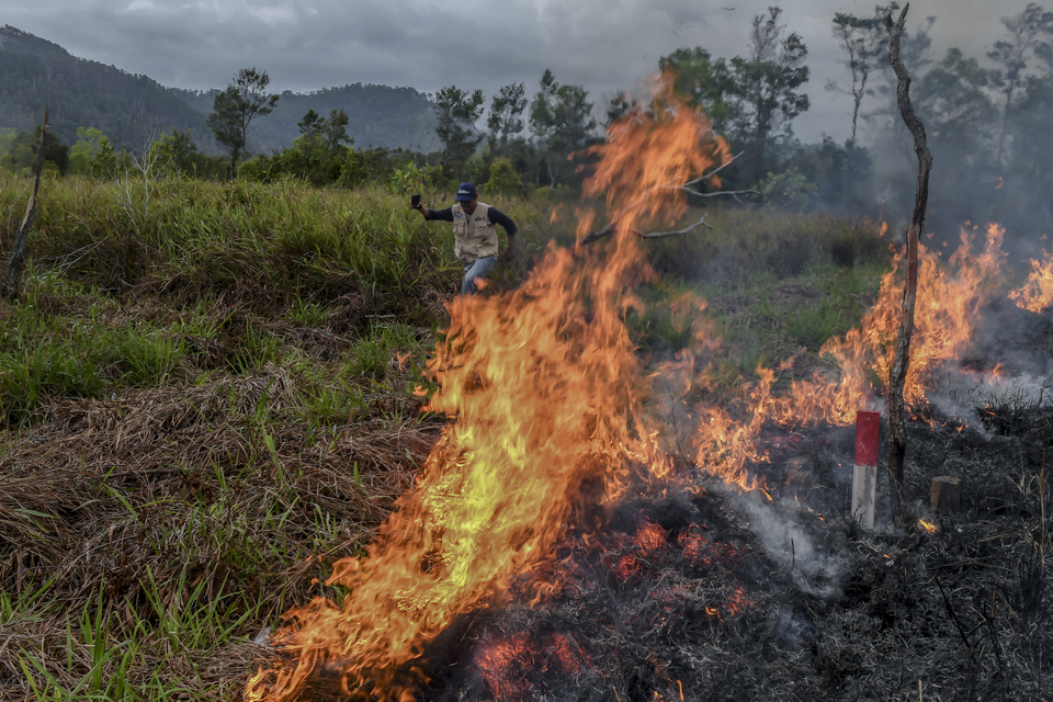 A man runs away from a bushfire in Natuna Islands on Sunday. (Antara Photo/Muhammad Adimaja)
