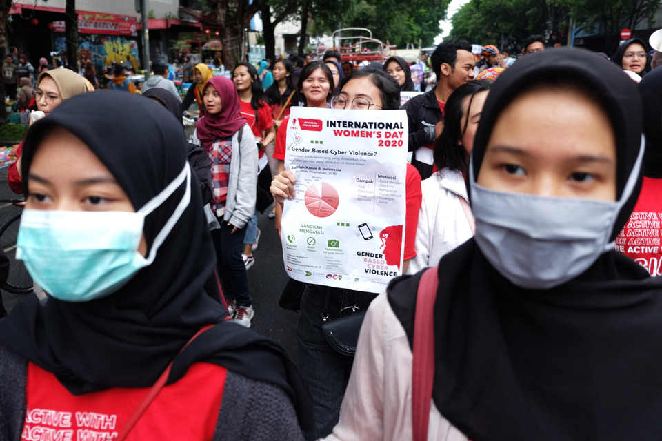 Protesters wear masks during an International Women's Day march in Solo, Central Java, on Sunday. (Antara Photo/Maulana Surya)