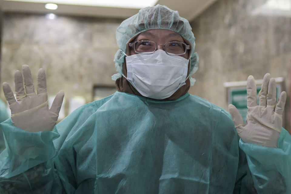 Vivi Setiawaty, the head of the center for research and development in biomedical and basic technology at the Health Ministry, wears protective clothing to enter a laboratory in Jakarta on Tuesday. (Antara Photo/Galih Pradipta)