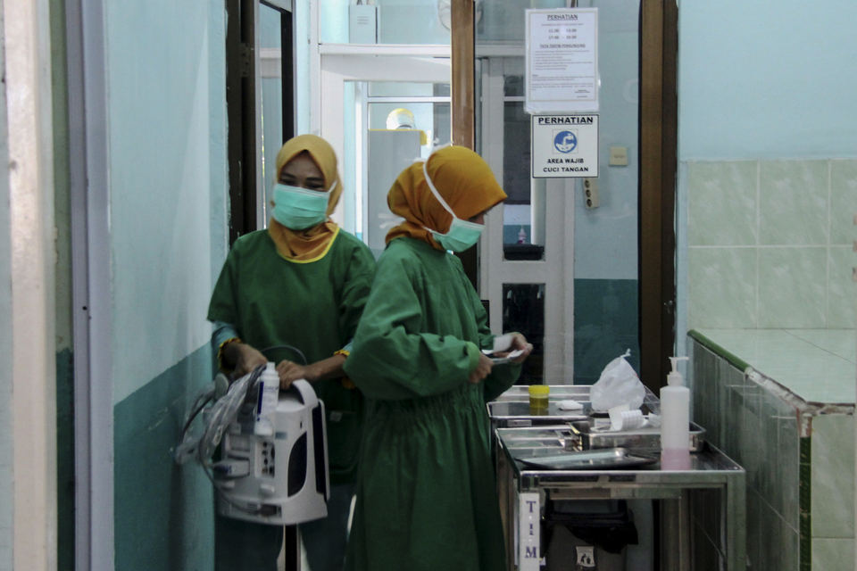 Two nurses clean up their medical equipment after examining a Covid-19 patient at Dumai Hospital in Riau on Friday. The patient has recovered after being treated for three days. (Antara Photo / Aswaddy Hamid)