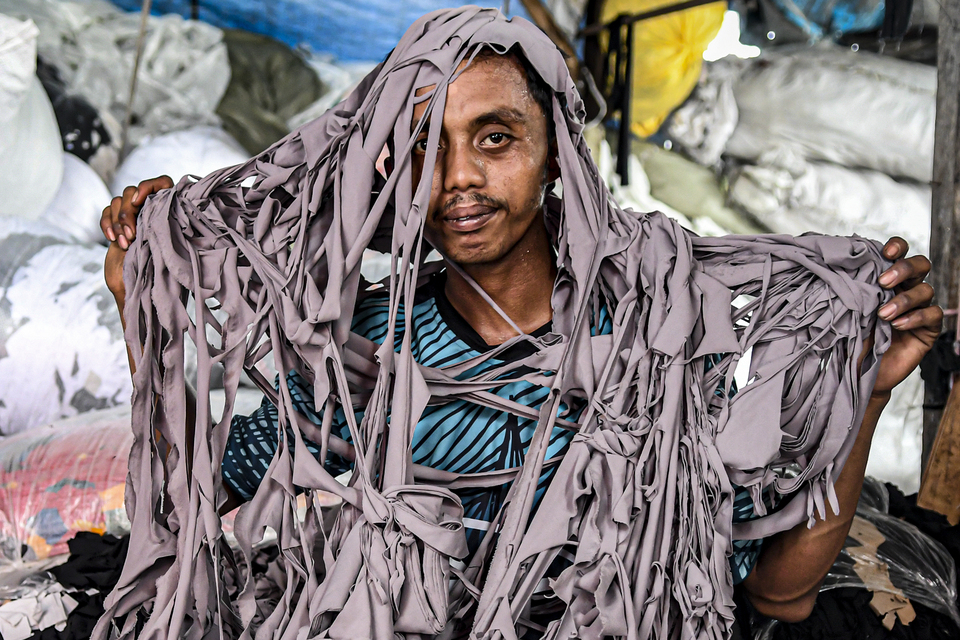 A scavenger collects scraps of used clothing from a slum in North Jakarta. (Antara Photo/Muhammad Adimaja)