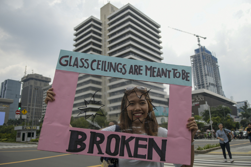 A woman holds up a placard during a Woman's Day march in Jakarta on March 8, 2020. (Antara Photo/Galih Pradipta)