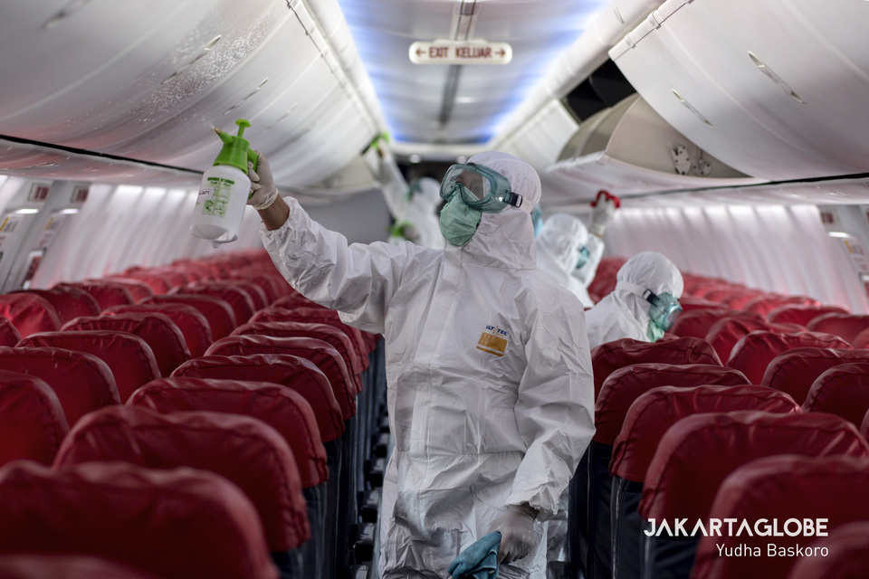 Airport health personnels spray disinfectant inside Lion Air's Boeing 737-800 plane. (JG Photo/Yudha Baskoro)