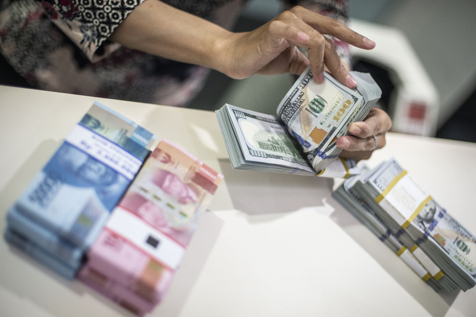 A teller counts US dollar banknotes in Jakarta. (Antara photo)