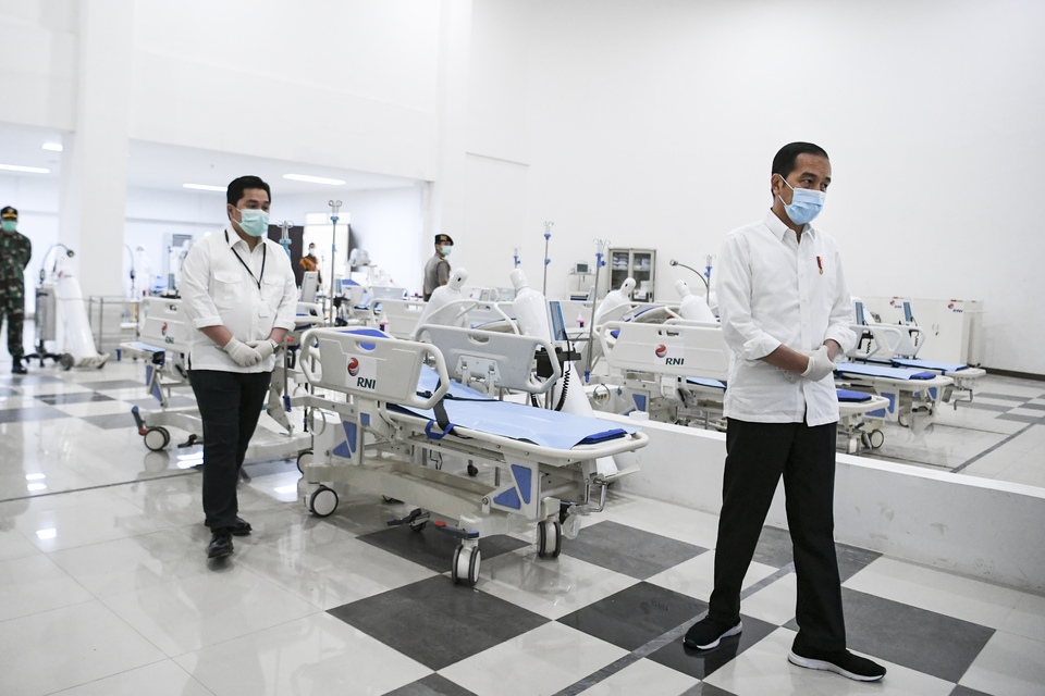 President Joko Widodo, right, and State-Owned Enterprises Minister Erick Thohir visit a makeshift hospital at the former Asian Games Athletes' Village in Kemayoran, Central Jakarta, on Monday. The facility is designated for Covid-19 patients. (Antara Photo/Hafidz Mubarak)
