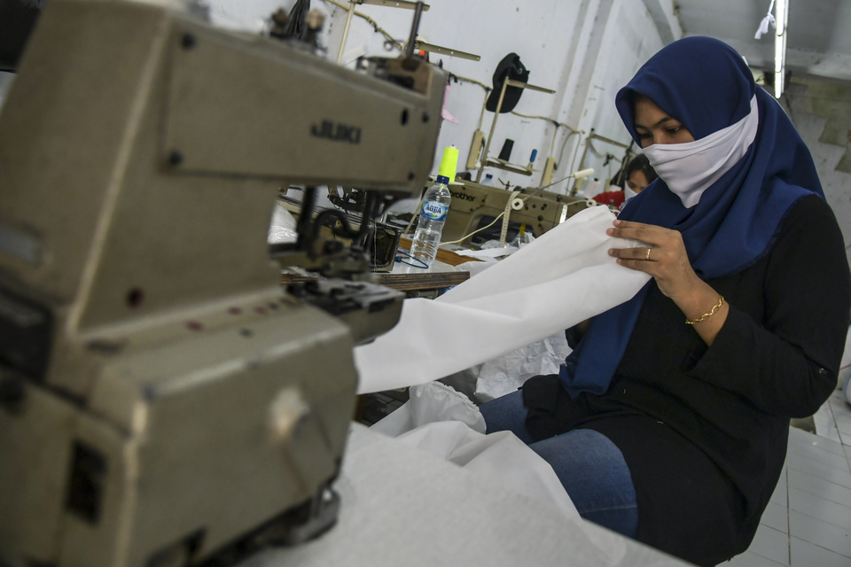A worker makes personal protective equipment for medical workers at the Small Industry Center in Jakarta on Thursday. (Antara Photo/Galih Pradipta)