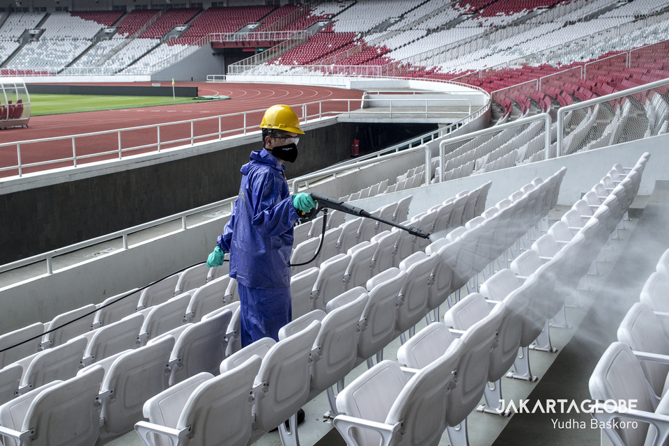 A worker disinfects benches at the GBK Stadium in Jakarta on Thursday. (JG Photo/Yudha Baskoro)