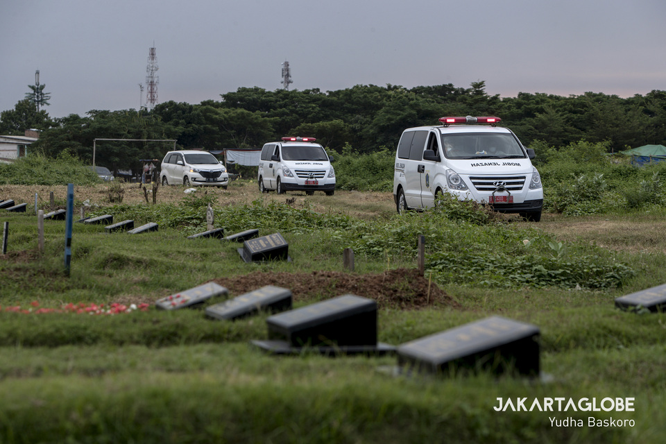 Ambulances carrying the bodies of suspect Covid-19 victims arrive at Tegal Alur public cemetery in West Jakarta on Thursday. (JG Photo/Yudha Baskoro)