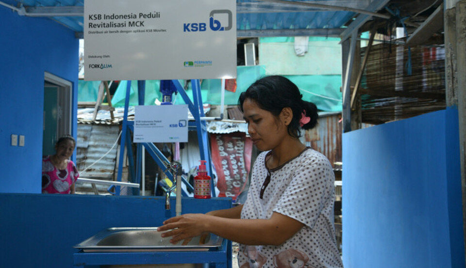 A woman washes her hands at a communal bathing facility in Karet Tengsin area. (Photo Courtesy of KSB Indonesia)