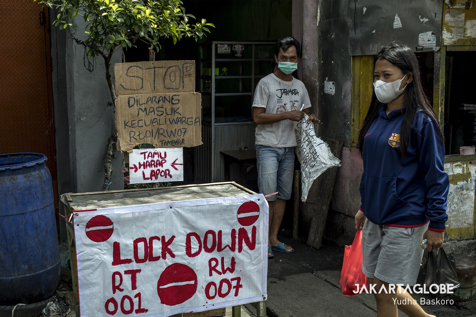 A man stands guard at the entrance of an alley in Tambora, West Jakarta, on Wednesday. (JG Photo/Yudha Baskoro)