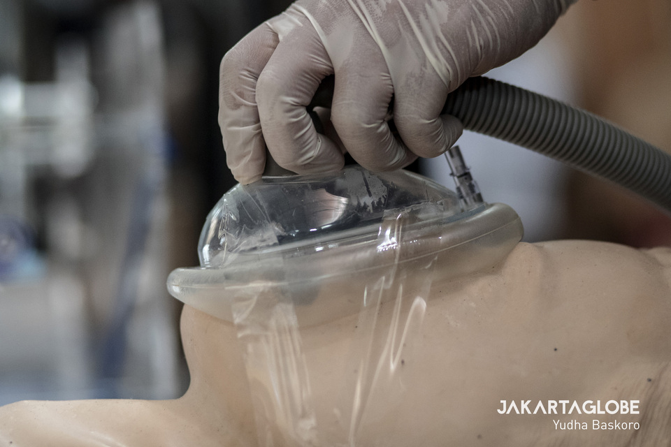 A worker demonstrates an emergency ventilator on a mannequin. (JG Photo/Yudha Baskoro)