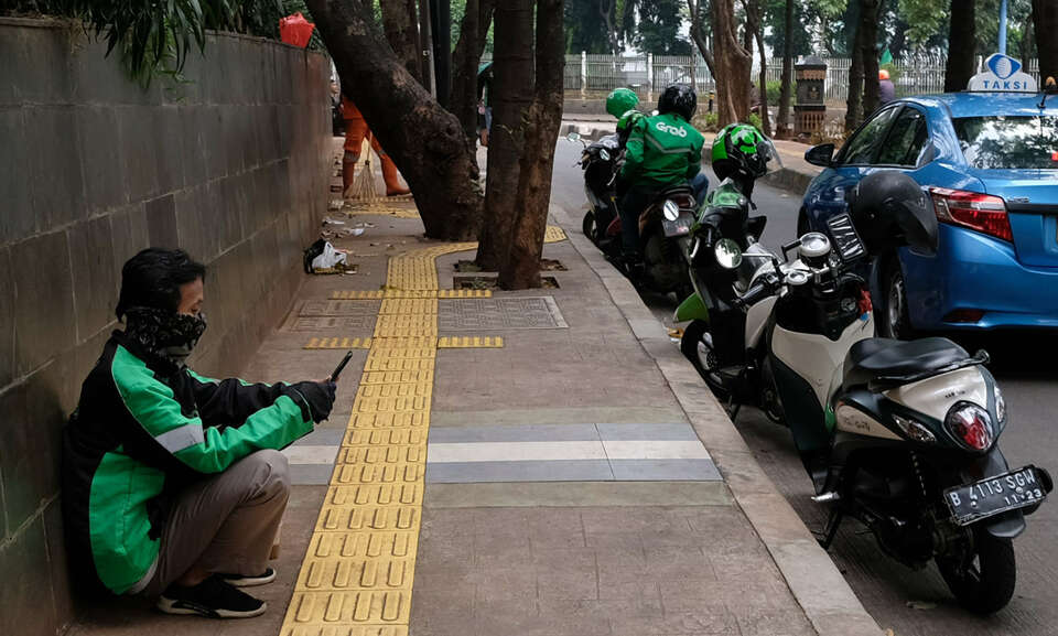 Online ojek drivers wait for orders during large-scale social restriction in Jakarta on Sunday. (SP Photo/Joanito De Saojoao)