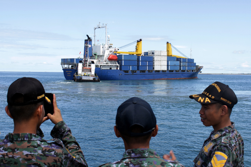 Port officers watch a cargo ship passing by Soekarno-Hatta Port in Makassar, South Sulawesi last month. (Antara Photo/Arnas Padda)