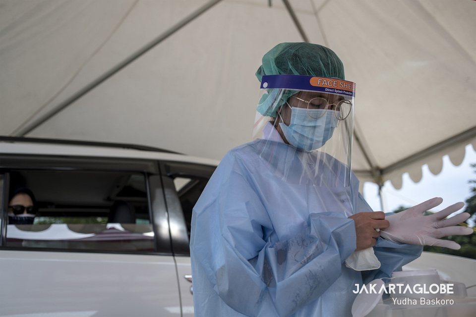 A health worker prepares to take a blood sample at a drive-thru diagnostic testing site in West Jakarta. (JG Photo/Yudha Baskoro)