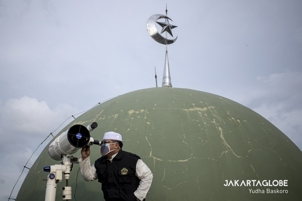 A muslim cleric tries to get an early view the moon up on the roof of the Al Musariin mosque in West Jakarta before the first day of Ramadan on Thursday. (JG Photo/Yudha Baskoro)