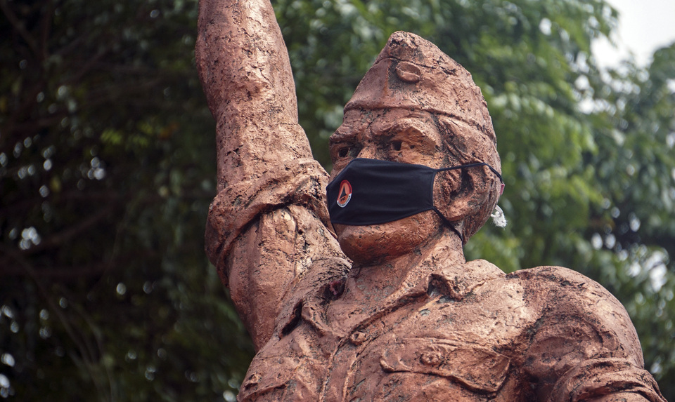 A cloth mask is strapped on a statue of an Indonesian World War II hero in Pekalongan, Central Java, on Monday. (Antara Photo/Harviyan Perdana Putra)