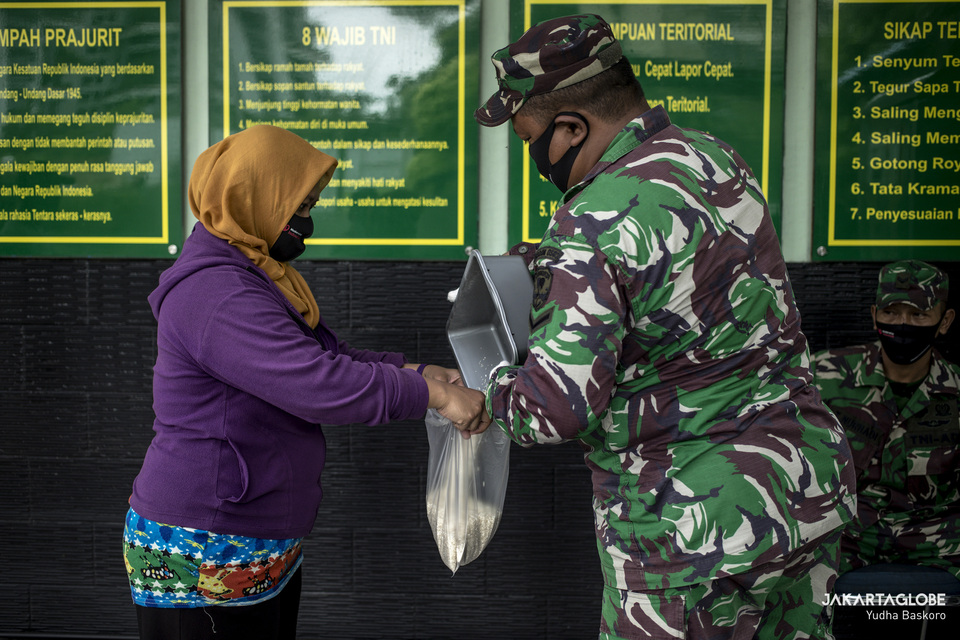 A woman receives a free bag of rice from a military-run 'Rice ATM' in West Jakarta on May 4. (JG Photo/Yudha Baskoro)