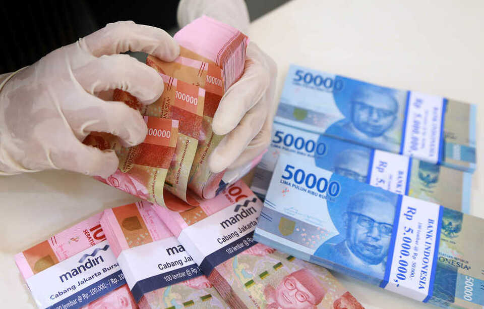A Bank Mandiri's Jakarta branch teller counts money on April 30. (B1 Photo/Mohammad Defrizal)