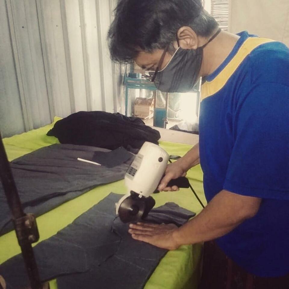 A man cuts fabric to be made into cloth masks at a Gerakan Kepedulian workshop. (Photo courtesy of GK Indonesia)
