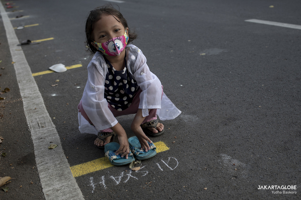 A girl marks her spot with flip-flops in a queue for free iftar meals in Cempaka Putih, Central Jakarta, last month. (JG Photo/Yudha Baskoro)