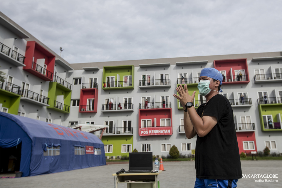 A medical worker leads an exercise at a makeshift Covid-19 isolation facility in Tangerang, Banten, as patients follow his instruction from their balconies on May 28, 2020. (JG Photo/Yudha Baskoro)