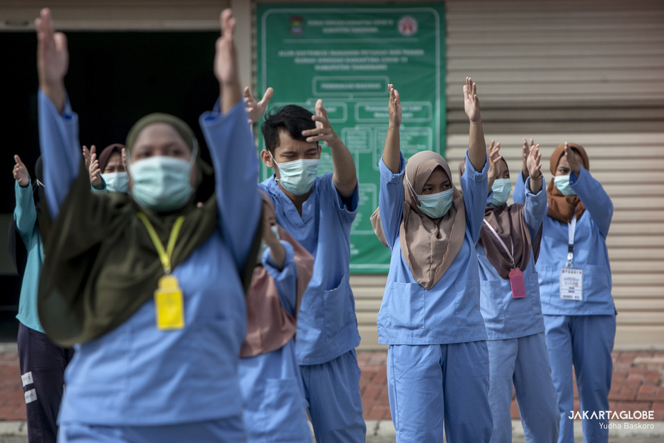 Coronavirus patients and medical workers exercise at an isolation faciity in Tangerang, Banten, on Thursday. (JG Photo/Yudha Baskoro)