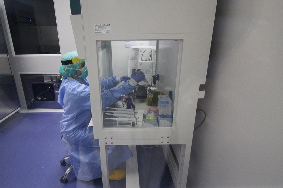A lab technician examines swab samples from suspected Covid-19 patients at Pelindo Husada Citra Hospital in East Java. (Antara Photo/Mochamad Asim)