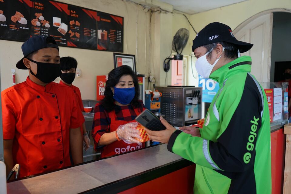 A Gojek driver picks up a food order from a restaurant in Jakarta. (Photo courtesy of Gojek)