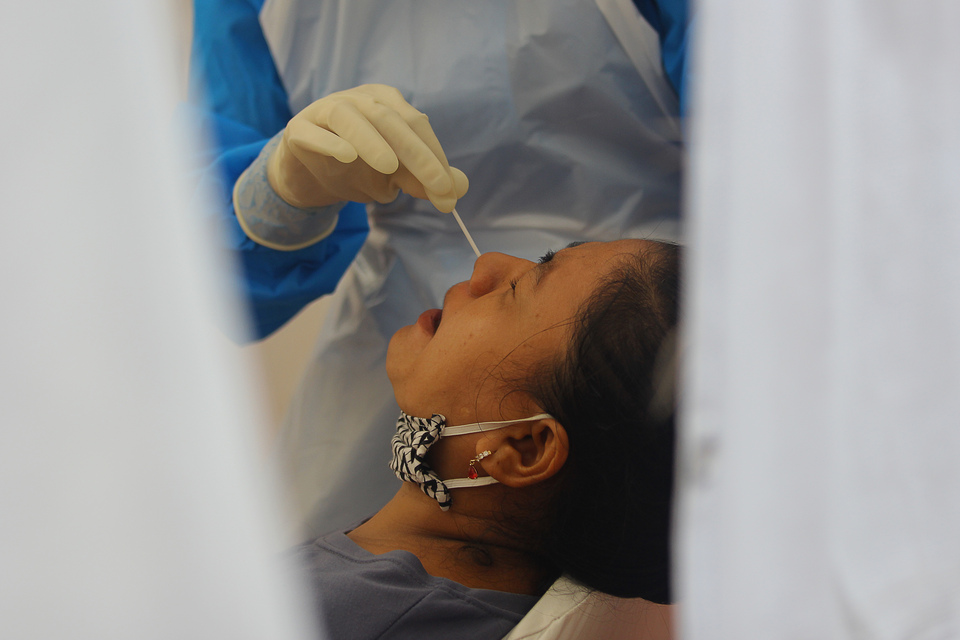 A health worker conducts a swab test in Surabaya, East Java, on Monday. (Antara Photo/Moch. Asim)